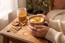 hands holding a cup of tea in a cozy setting