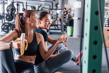 Two ladies eating while working out 