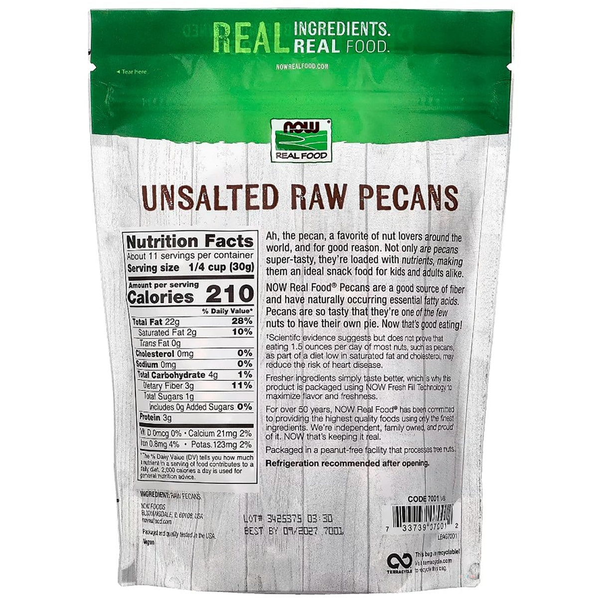 NWF1179 | shelled pecans scattered on a wooden cutting board with the product pouch blurred in the background