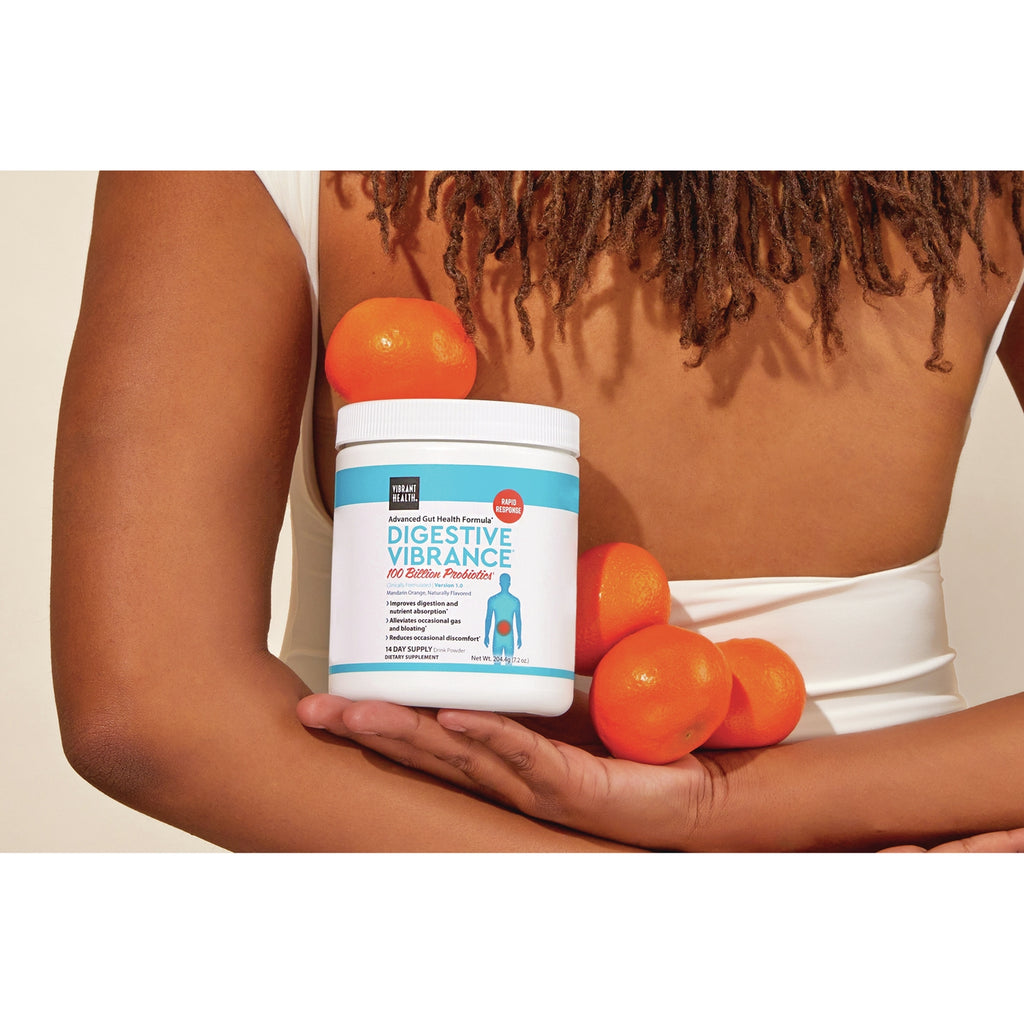 VH042 | Woman holding Digestive Vibrance supplement jar with oranges - Thumbnail