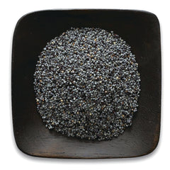 FNP079 | heap of blue-gray poppy seeds on a dark square wooden plate