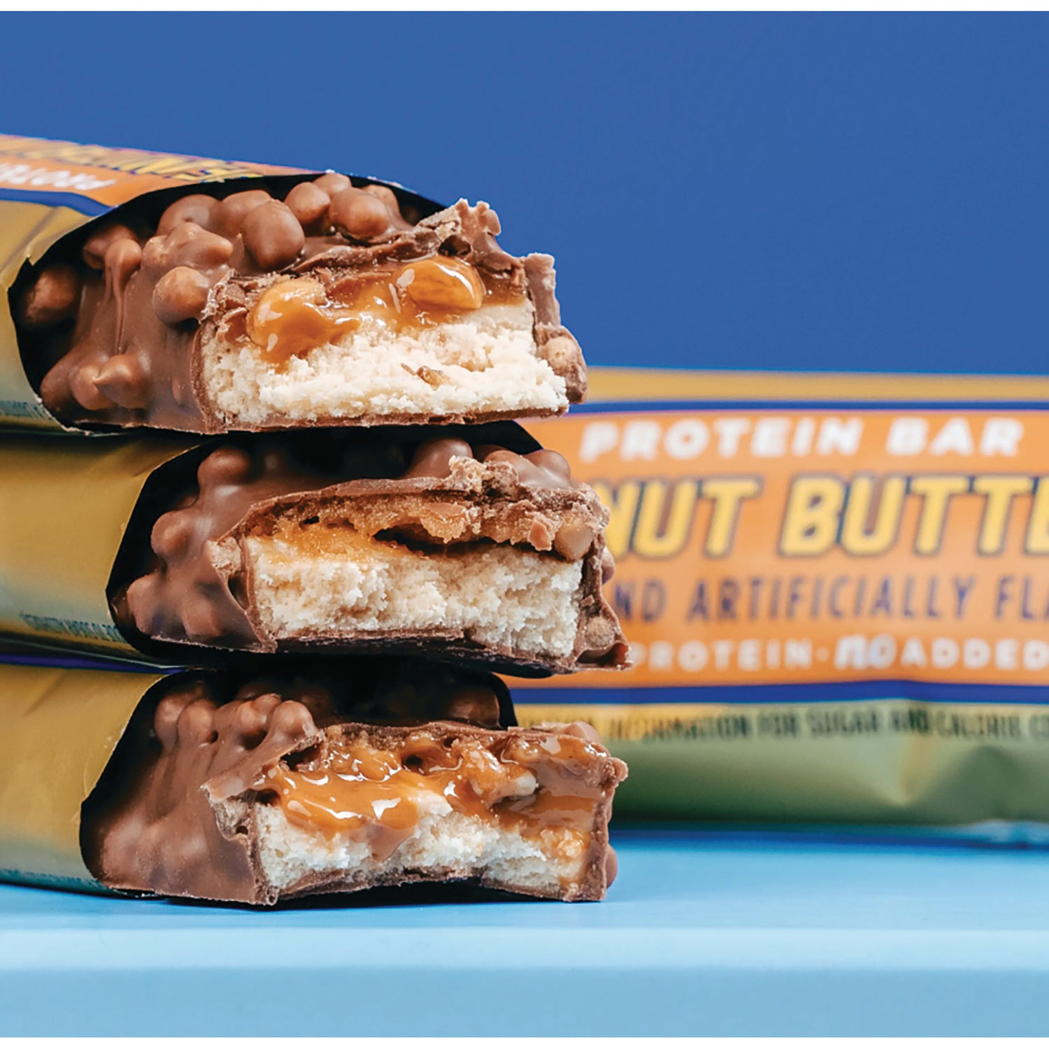 BAE004 | Three stacked chocolate-covered peanut butter protein bars showing caramel and nougat cross-sections