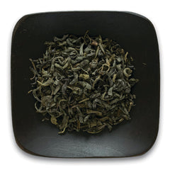 FNP083 | loose dried green tea leaves in a dark square dish
