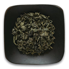 FNP031 | rolled green tea leaves in a dark square dish on white background