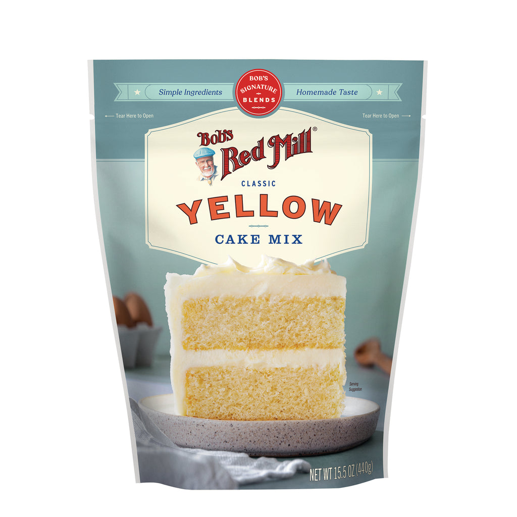 BOB481 | Bob's Red Mill Yellow Cake Mix pouch with two-layer frosted cake slice on a plate - Thumbnail