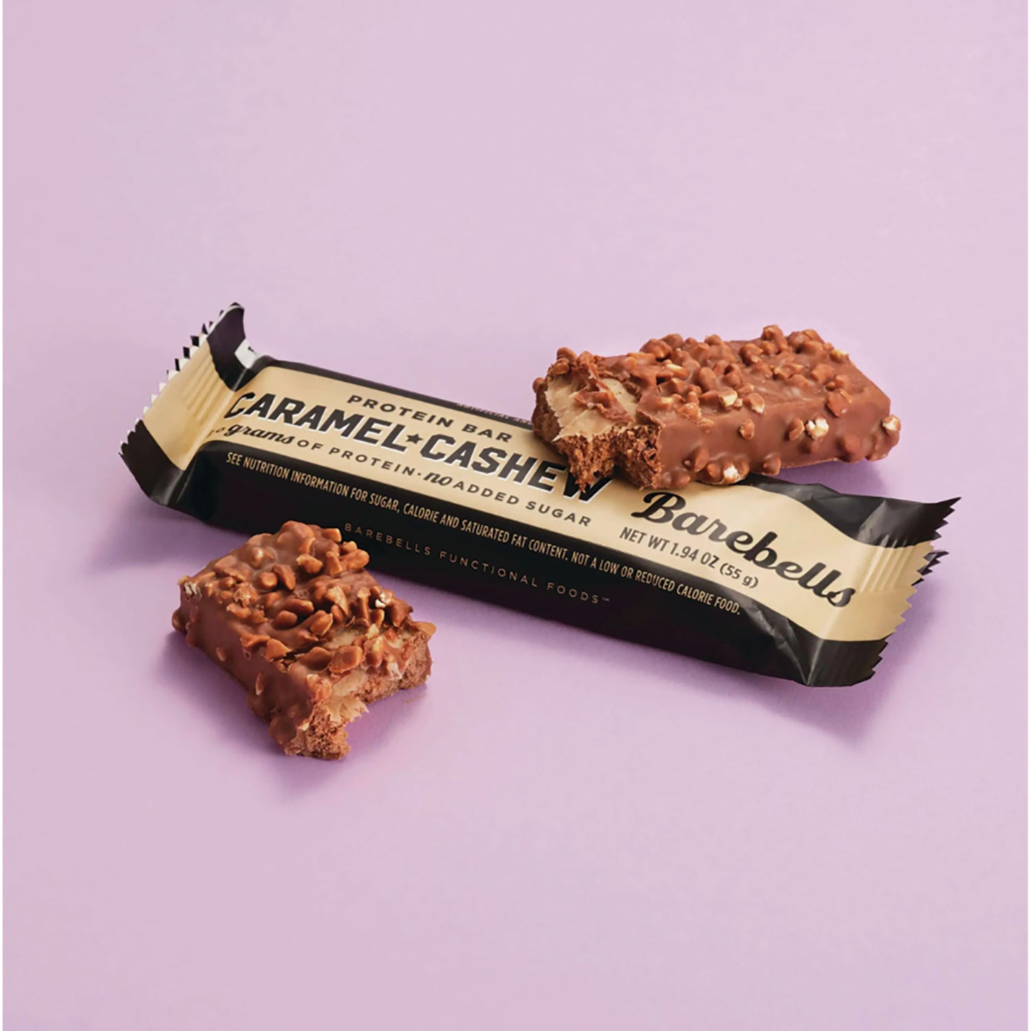 BAE001 | Caramel Cashew protein bar and two bitten pieces on pale purple background