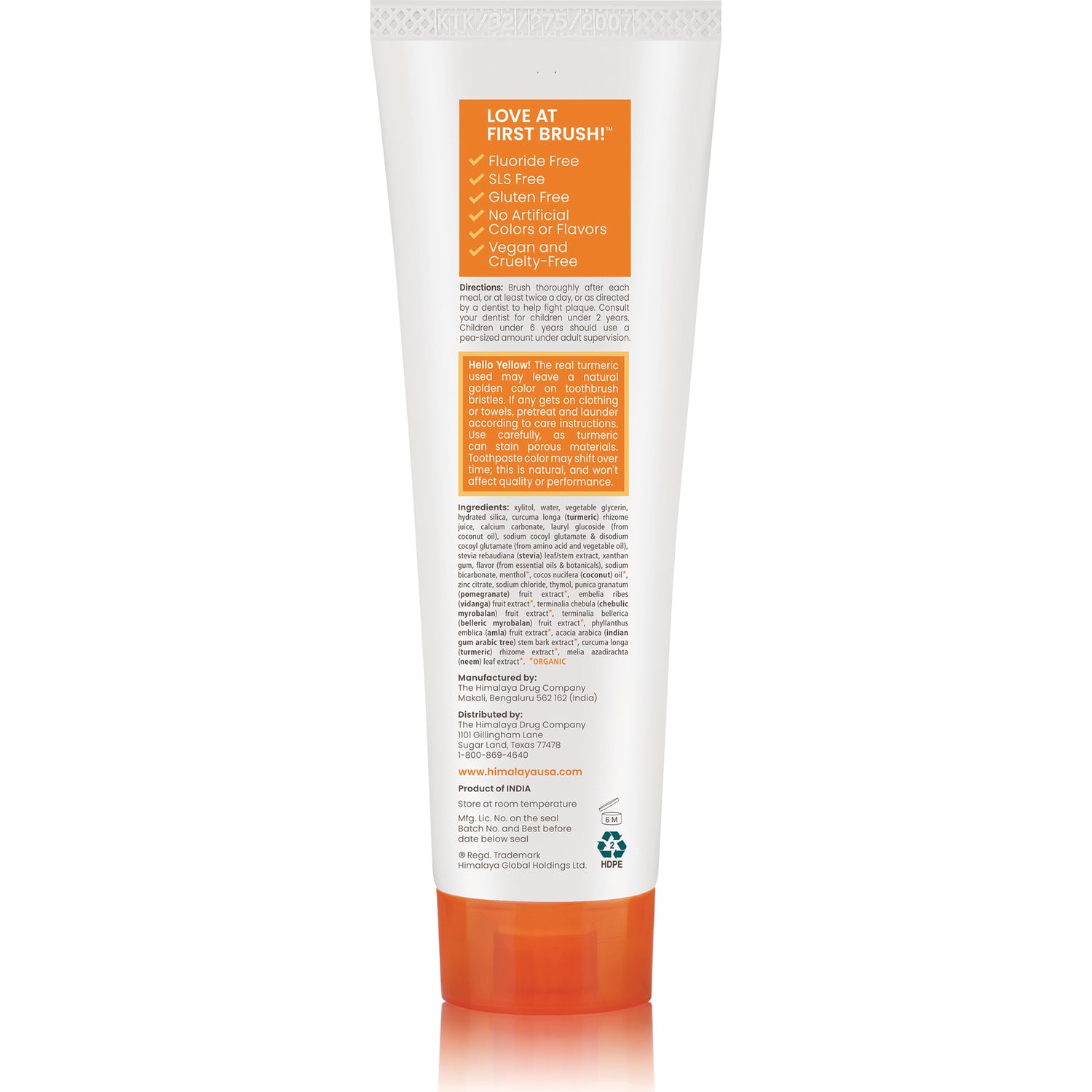 HHH055 | Back of white toothpaste tube with orange cap and orange panel reading LOVE AT FIRST BRUSH and ingredient text