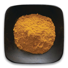 FNP037 | mound of bright orange powdered spice on a black square plate