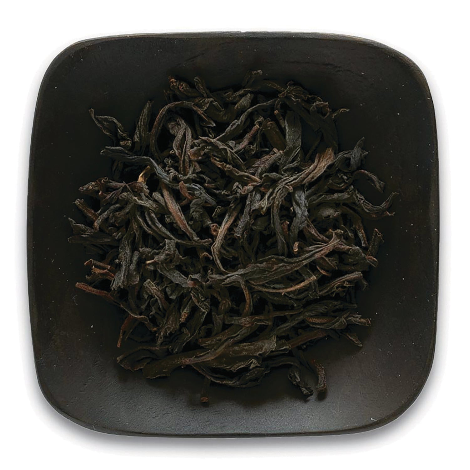 FNP085 | Top-down view of loose dried black tea leaves in a square dark ceramic dish