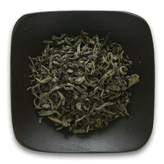 FNP028 | loose dried green tea leaves on a dark square plate
