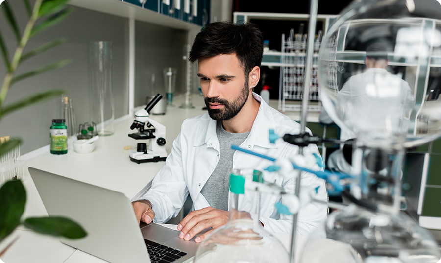 Scientist working on a laptop in a laboratory setting