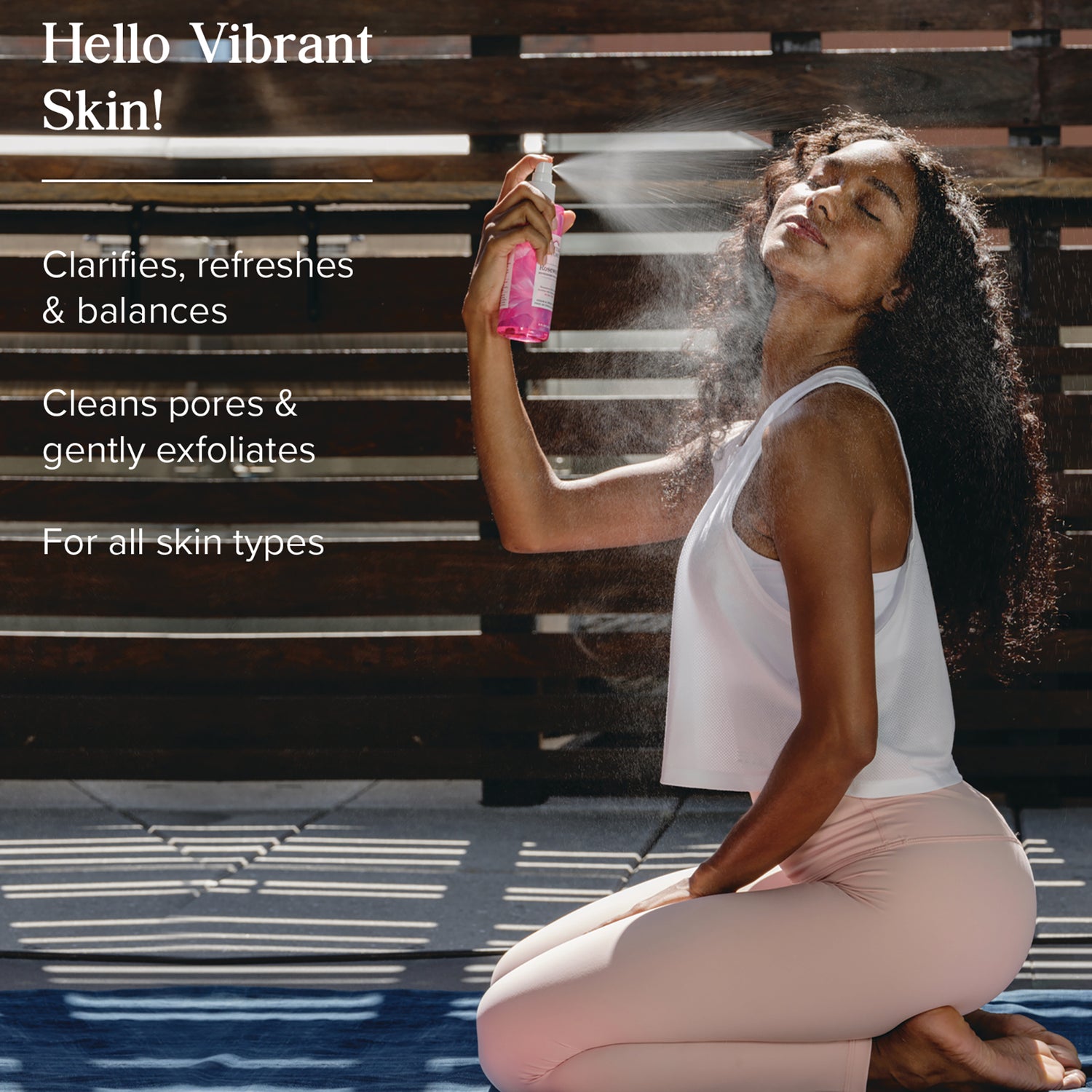 HTG110 | Woman kneeling sprays pink facial mist, overlay text Hello Vibrant Skin and clarifies, refreshes & balances