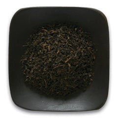 FNP080 | Loose black tea leaves piled in a square black dish