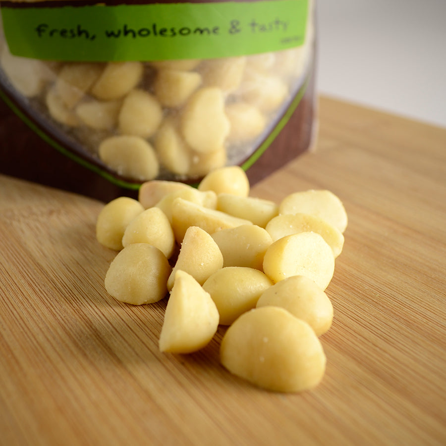 NWF980 | macadamia nuts spilled on a wooden board with a bag labeled Fresh, wholesome & tasty in the background