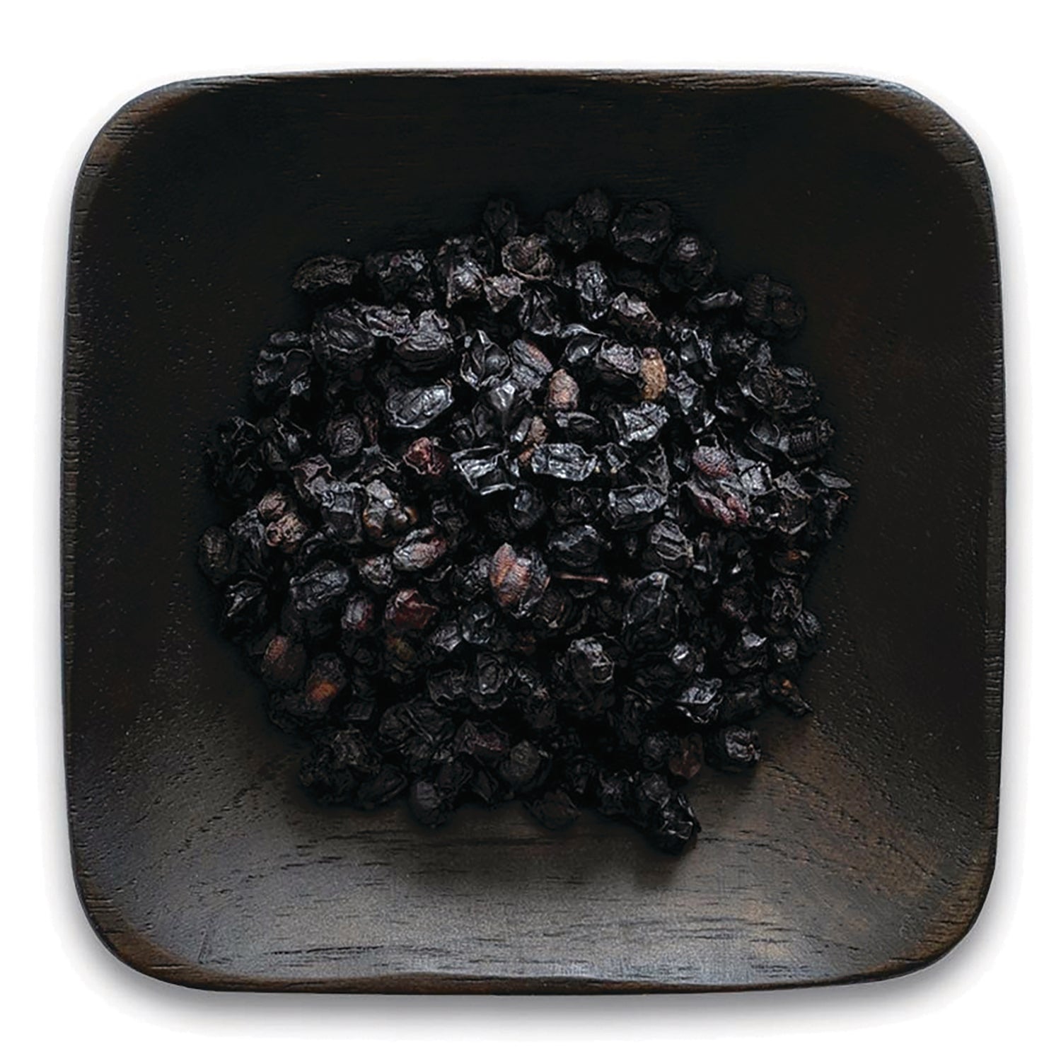 FNP380 | pile of dried dark berries in a square wooden dish on white background