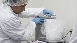Person in a lab working with a container.