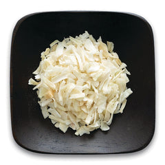 FNP064 | pile of shredded white coconut flakes on a dark square plate