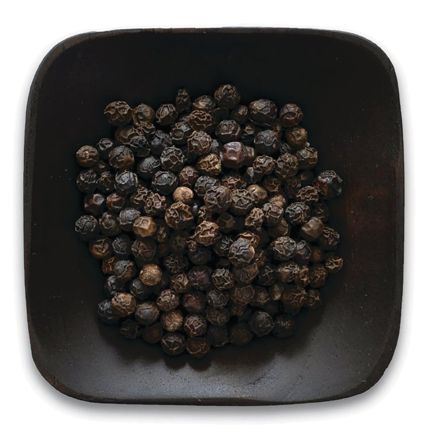 FNP039 | pile of whole black peppercorns in a dark square bowl on white background