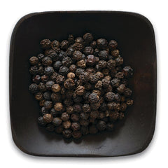 FNP039 | pile of whole black peppercorns in a dark square bowl on white background