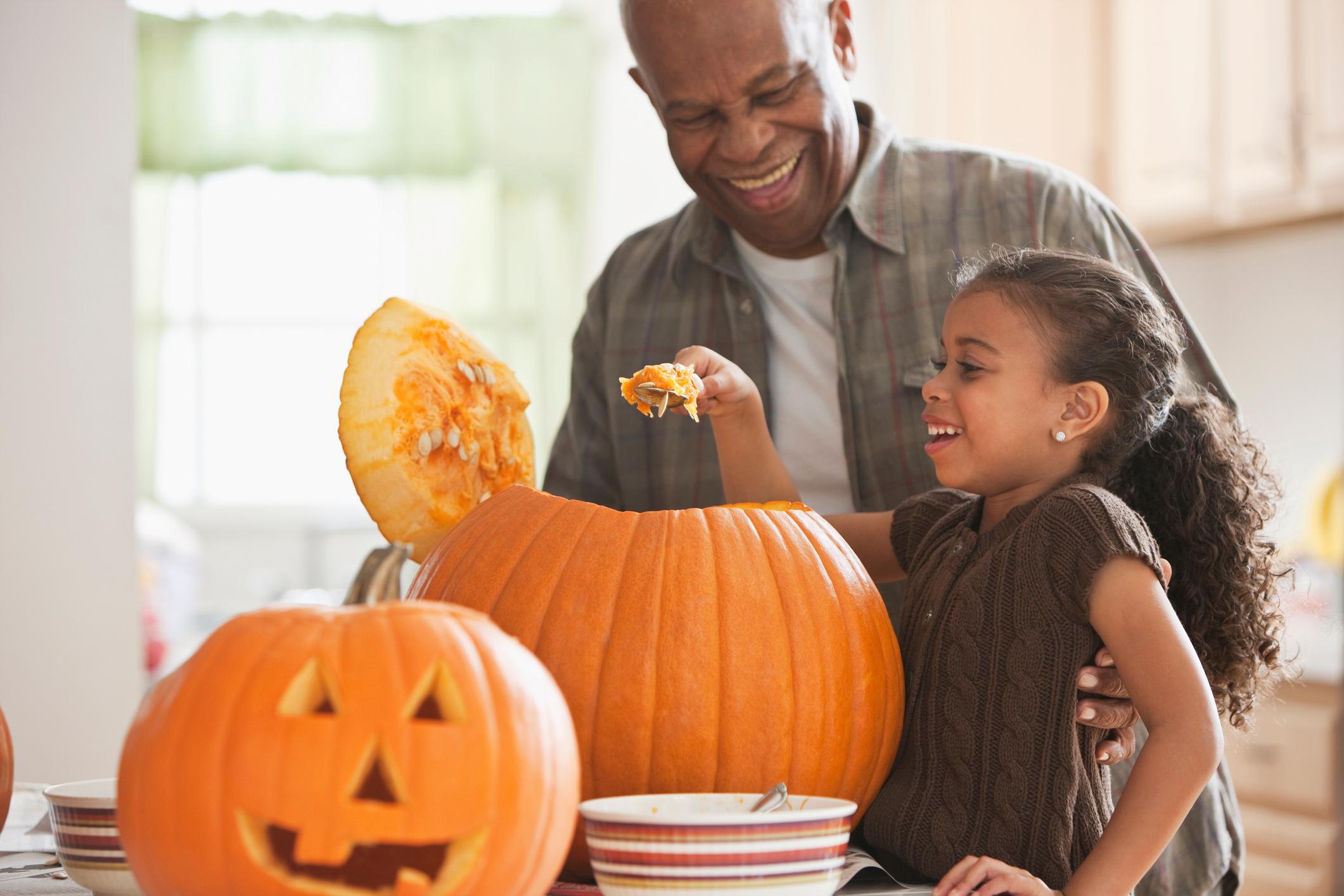 grandfather and granddaughter carving a pumpkin