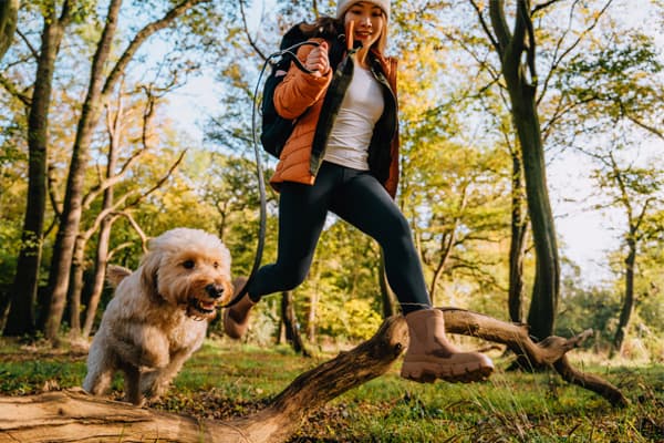 a woman and a dog running together
